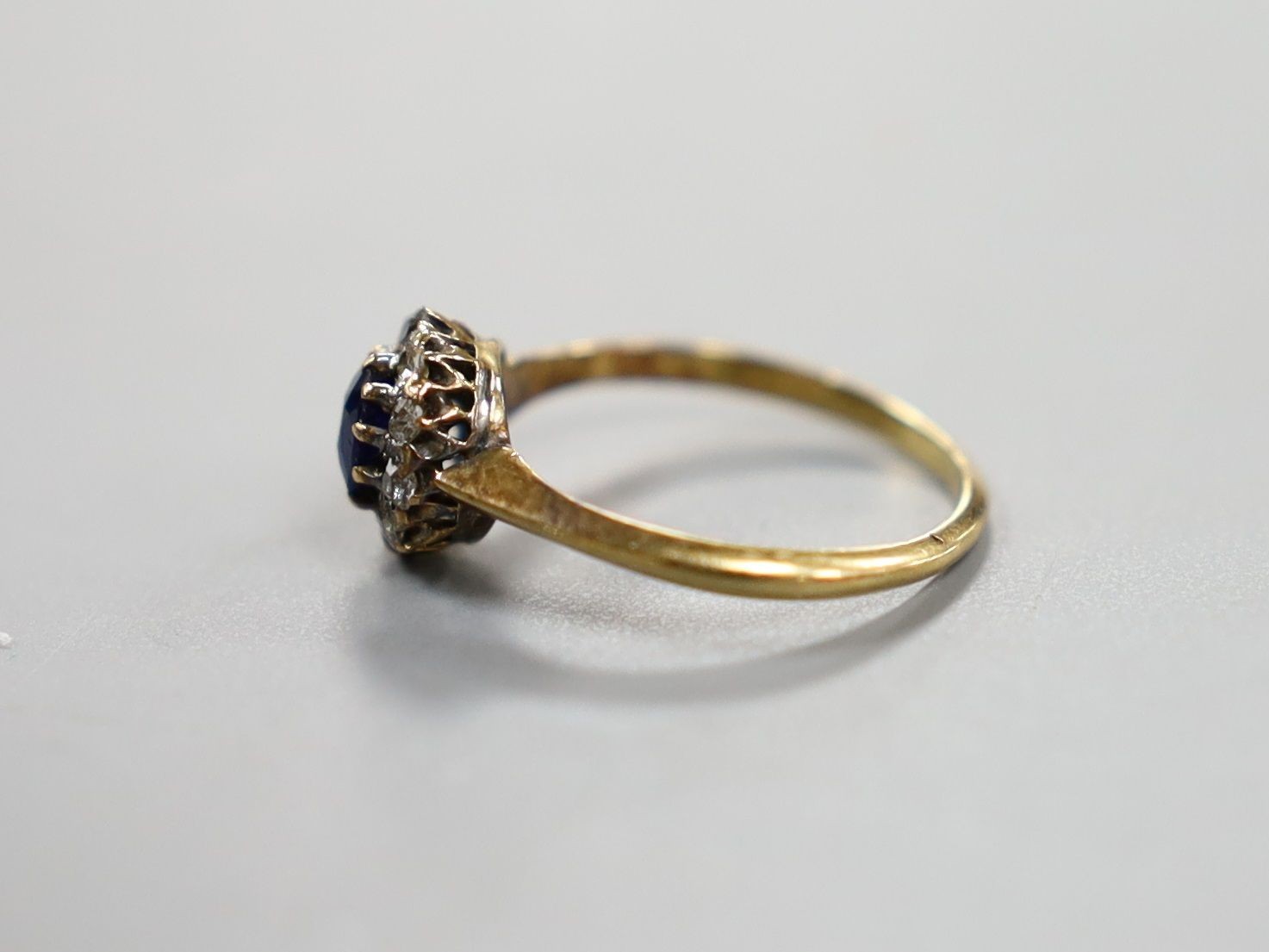 An early 20th century yellow metal, sapphire and diamond set oval cluster ring, size I/J, gross weight 1.7 grams.